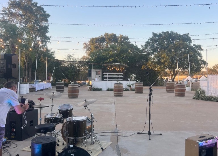 Charter Music Duo stage and live sound setup on concrete apron under festoon lights
